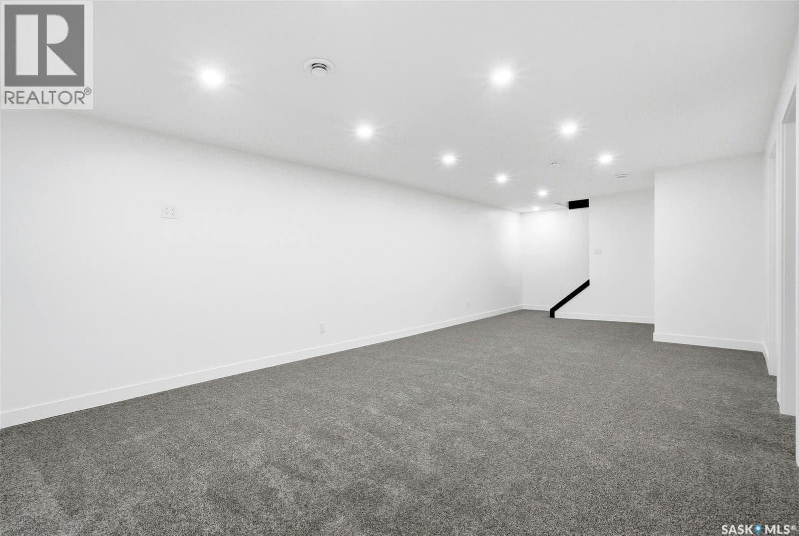 A cluttered kids' room with mismatched furniture, toys scattered on the floor, and plain white walls.